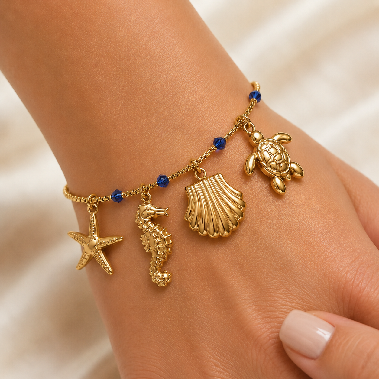 Goldenes Sommer Armband mit Meeres Charms getragen am Handgelenk