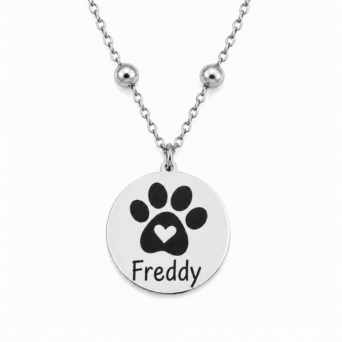 Silbernes personalisiertes Edelstahl Armband mit rundem Anhänger, Pfotenmotiv mit Herz und Name Freddy auf weißem Hintergrund