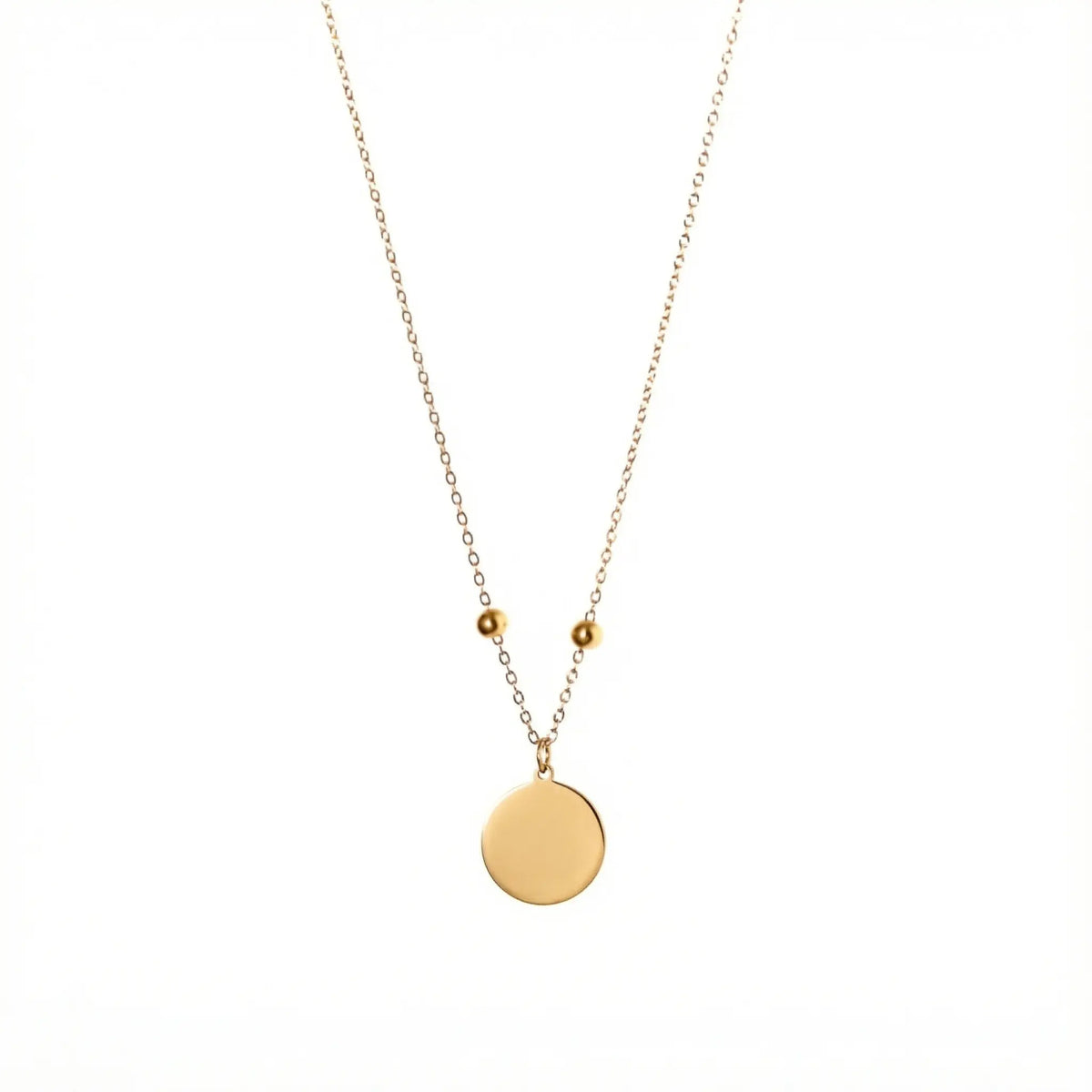 Goldfarbene Edelstahlkette mit zwei kleinen Stopper-Perlen und einem glatten, runden Anhänger, der individuell mit einer Zeichnung graviert werden kann.