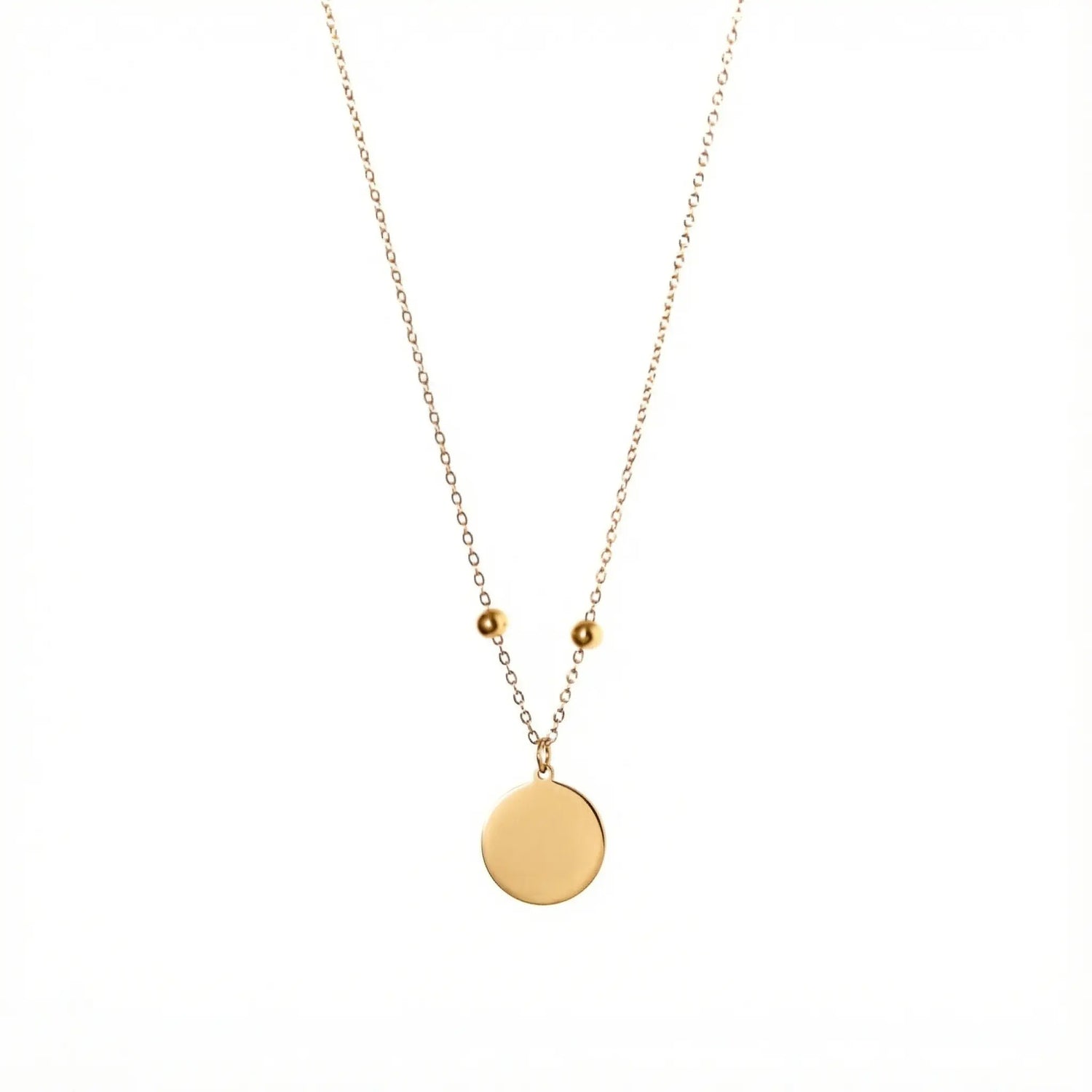 Goldfarbene Edelstahlkette mit zwei kleinen Stopper-Perlen und einem glatten, runden Anhänger, der individuell mit einer Zeichnung graviert werden kann.