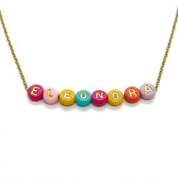 Detailaufnahme einer personalisierten Namenskette mit bunten Buchstaben-Perlen auf goldener Kette