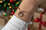 Goldenes Fingerabdruck-Armband aus Edelstahl am Handgelenk, weihnachtliche Szene