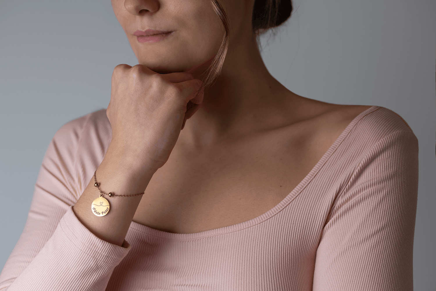 Frau trägt personalisiertes Love-Duo Armband mit Herzsymbol in Gold