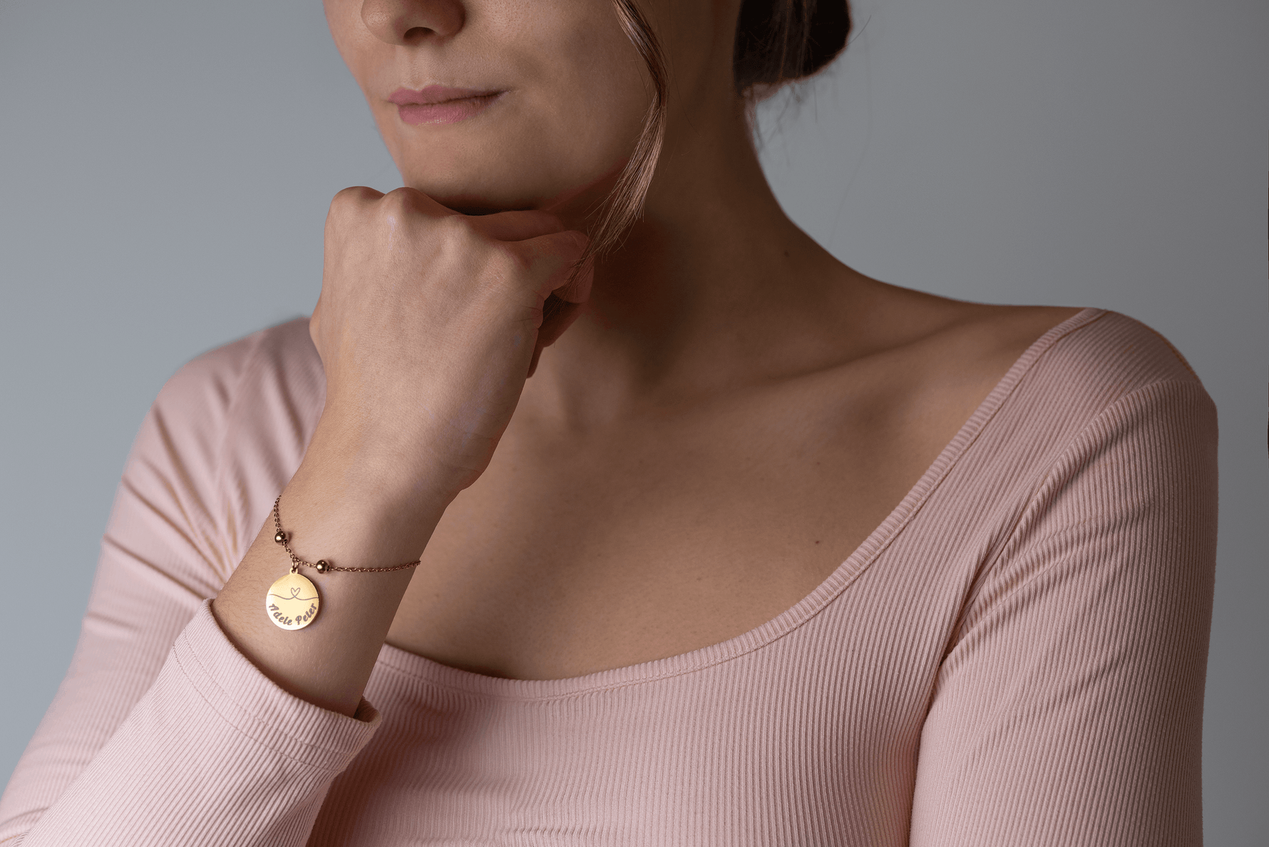 Frau trägt personalisiertes Love-Duo Armband mit Herzsymbol in Gold